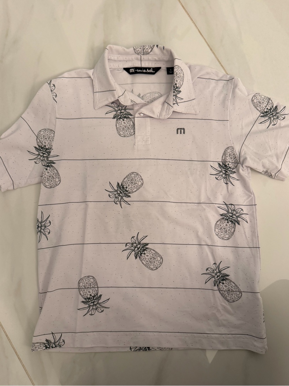 Travis Mathew White Polo with Black Pineapple Print